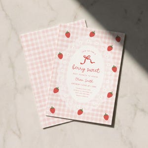 Könnte beinhalten: Babyparty-Einladung mit rosa Vichy-Muster und einem ovalen Spitzenmuster. Der Text "berry sweet" ist in roter Schrift geschrieben, umgeben von roten Erdbeer-Illustrationen.