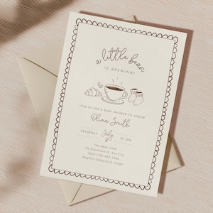 May include: A baby shower invitation with a scalloped border and the words "a little bean is brewing!" in a script font. The invitation includes illustrations of a coffee cup, croissant, and baby socks. The invitation is on a cream-colored background.