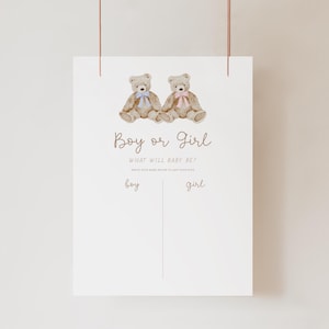 Op de afbeelding: Een wit bord met twee teddyberen, één met een blauwe strik en de andere met een roze strik. De tekst luidt "Boy or Girl" boven "What will baby be?" met lijnen voor namen. Een babyshower spel.
