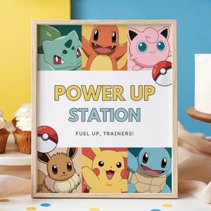 Pode incluir: Uma moldura de madeira retangular contendo uma placa com o texto POWER UP STATION e FUEL UP, TRAINERS! A placa apresenta ilustrações coloridas de Bulbasaur, Charmander, Jigglypuff, Eevee, Pikachu, Squirtle e duas Poké Balls vermelhas e brancas.