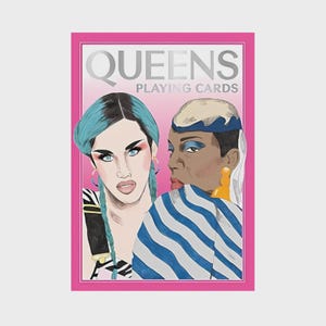 May include: A deck of "QUEENS PLAYING CARDS" with a pink border. The card features illustrations of two people with striking makeup and hairstyles. One has blue hair and the other has a blue and white striped top.