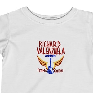 May include: White baby onesie with a red graphic of a guitar with wings. The text reads "Richard Valenzuela and his Flying Guitar".