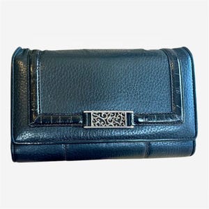 May include: Black leather wallet with a textured finish. The wallet features a silver-tone decorative clasp with an ornate design. The edges have a glossy, crocodile-like texture.