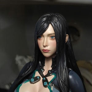 K&ouml;nnte beinhalten: Eine detaillierte Figur, die einen Charakter mit langem, glattem schwarzem Haar, leuchtend blauen Augen und einem neutralen Ausdruck darstellt. Die Figur tr&auml;gt ein eng anliegendes dunkelblau-graues Outfit mit t&uuml;rkisfarbenen Akzenten am Ausschnitt.