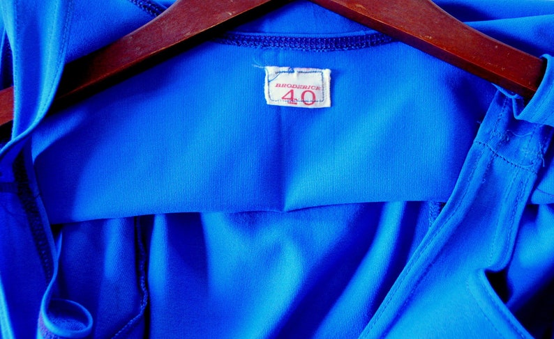May include: A bright blue hooded shirt with a white tag that says "MARCADOR" and "40" in red.