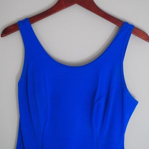 May include: A sleeveless royal blue dress with a scoop neck and a fitted bodice.