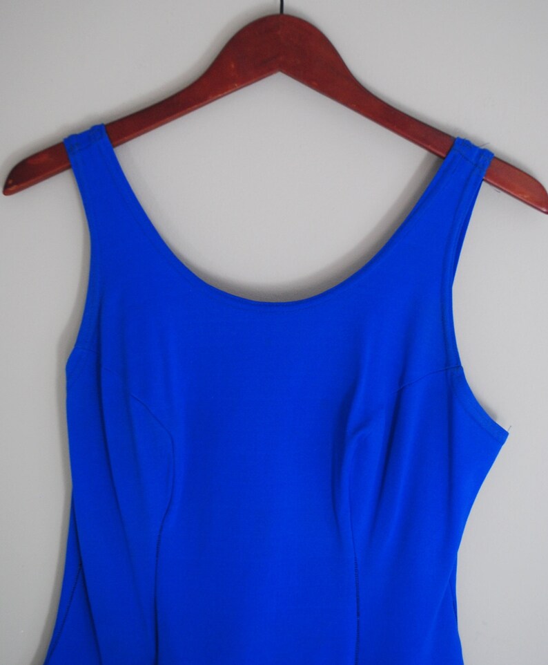 May include: A sleeveless royal blue dress with a scoop neck and a fitted bodice.