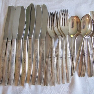 May include: A set of silverware with a floral design. The set includes knives, forks, and spoons.