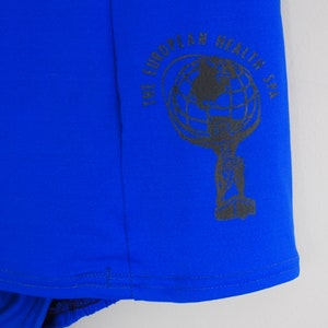 May include: A royal blue fabric with a black and white logo that reads "The European Health Spa". The logo features a globe with a key.