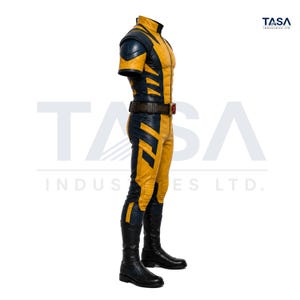 Puede incluir: Un mono de manga corta en color amarillo y azul marino con cuello alto, paneles texturizados en los hombros y un cintur&oacute;n utilitario marr&oacute;n con un emblema de X roja. La prenda se combina con botas negras. El texto TASA INDUSTRIES LTD. aparece en la esquina.
