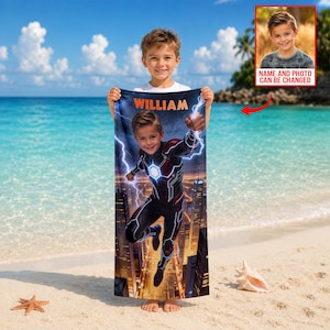 Puede incluir: Una toalla de playa personalizada con un dise&ntilde;o de superh&eacute;roe y el nombre "WILLIAM" en naranja. La toalla muestra a un ni&ntilde;o con un traje de superh&eacute;roe, rayos y un paisaje urbano. El fondo es una playa.