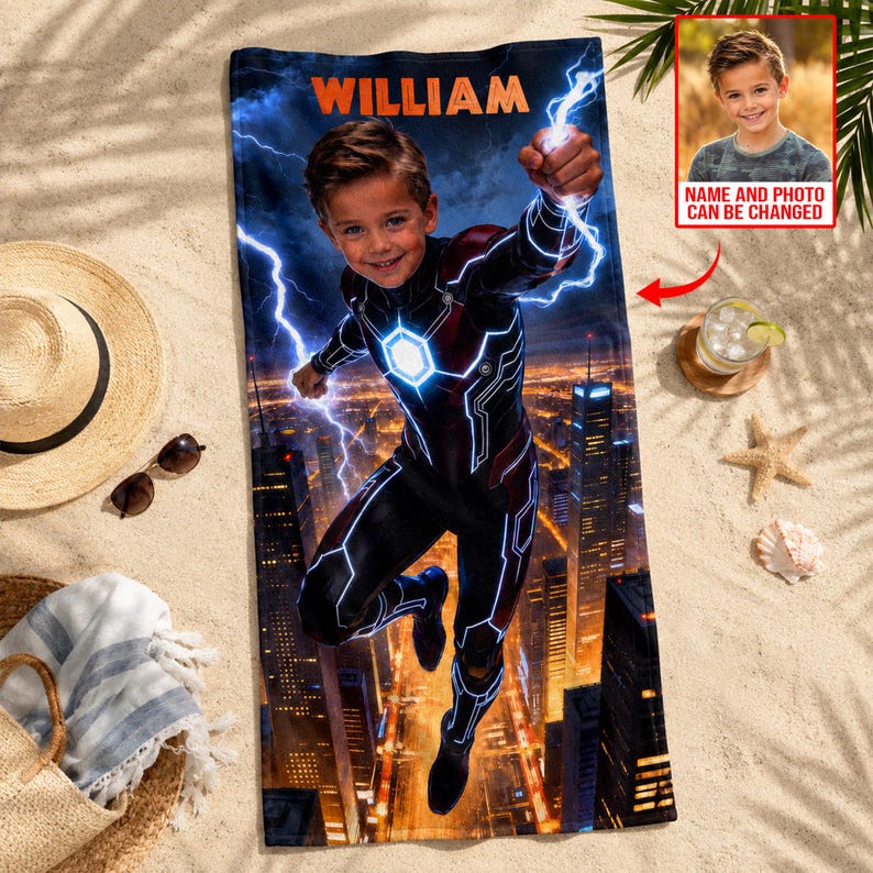 Puede incluir: Una toalla de playa personalizada con un dise&ntilde;o de superh&eacute;roe. Presenta a un ni&ntilde;o con un disfraz con rayos y un fondo de ciudad. El nombre "WILLIAM" est&aacute; impreso en la parte superior. Una peque&ntilde;a foto del ni&ntilde;o est&aacute; en la esquina. La toalla est&aacute; en una playa de arena.