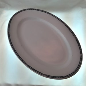 May include: White oval serving platter with a black and gray geometric border.