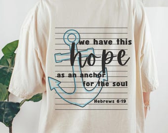 May include: A cream-coloured t-shirt featuring a blue anchor design and the words "we have this hope as an anchor for the soul" in black script. The text "Hebrews 6:19" is also printed on the shirt.