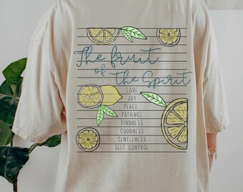 May include: Cream-coloured t-shirt featuring a lemon-themed design on the back. The graphic includes lemon slices, leaves, and the text "The fruit of the Spirit" with virtues: Love, Joy, Peace, Patience, Kindness, Goodness, Gentleness, and Self Control.