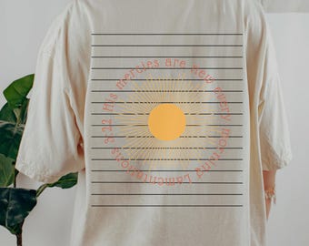 May include: Cream-coloured t-shirt with a graphic on the back. The graphic features a yellow sunburst design inside a circle, with the text "3:22 His mercies are new every morning Lamentations". The shirt has a relaxed fit.