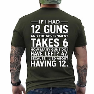 May include: An olive green short-sleeved t-shirt featuring white text on the back that reads: IF I HAD 12 GUNS AND THE GOVERNMENT TAKES 6 HOW MANY GUNS DO I HAVE LEFT? 47. BECAUSE I LIED ABOUT HAVING 12.