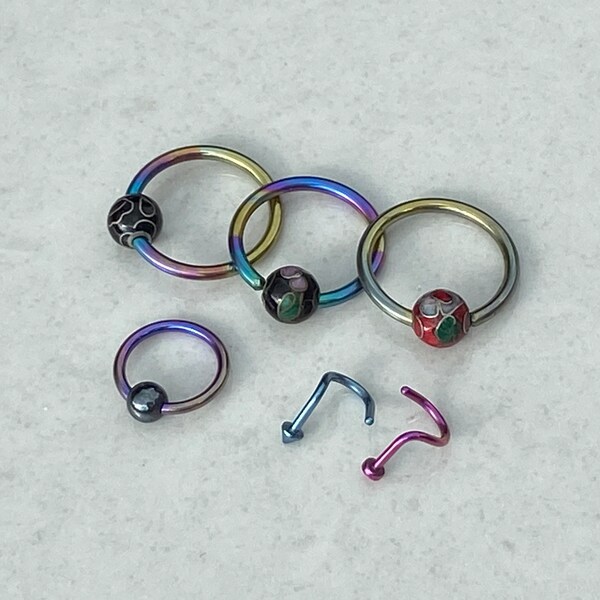 A selection of Rainbow Titanium, Anodised Titanium Body Piercing Jewellery, Hoops, Ball Closure, Nose spirals. Cloisonne Bead Balls.