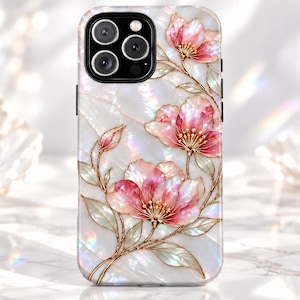 Könnte beinhalten: Eine Smartphone-Hülle mit perlmuttweißem Hintergrund und irisierendem Glanz. Das Design zeigt zarte rosa Blüten und grüne Blätter mit goldfarbenen Umrandungen, die ein florales Muster über die gesamte Oberfläche bilden.