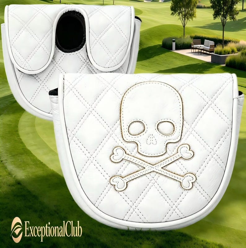 May include: A white mallet putter headcover featuring a quilted diamond pattern and an embroidered skull and crossbones design. The cover has a rounded shape with a black interior lining and a secure closure mechanism for golf equipment protection.