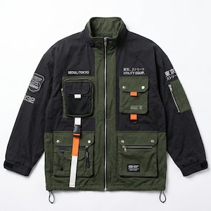 Puede incluir: Una chaqueta utilitaria negra y verde oliva con cremallera frontal completa, cuello alto y múltiples bolsillos cargo. La chaqueta incluye texto en blanco que dice SEOUL/TOKYO, UTILITY EQUIP y caracteres japoneses, con detalles de correas naranjas.