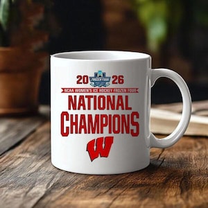 Puede incluir: Taza de cer&aacute;mica blanca con el texto "2026 Frozen Four" y "NCAA Women's Ice Hockey Frozen Four National Champions" en rojo. La taza tambi&eacute;n presenta un logotipo "W" rojo, ideal para un aficionado al deporte.
