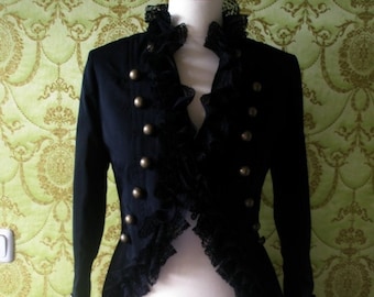 May include: A black jacket with a lace trim and gold buttons. The jacket has a long tail in the back.