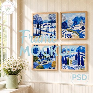 May include: Four framed art prints with blue and white landscape paintings. The frames are light wood. The text "Frame Mockup" is in light blue. A vase of daisies sits on a windowsill.