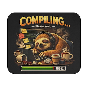 May include: A rectangular mouse pad featuring a brown sloth wearing headphones while typing on a laptop. The text reads COMPILING... Please Wait. A progress bar at the bottom shows 99%. Several coffee mugs and sticky notes are on the desk.