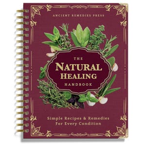 May include: A spiral-bound book titled "The Natural Healing Handbook" with a burgundy cover. The cover features an illustration of various herbs and garlic cloves. Gold accents and text are present.