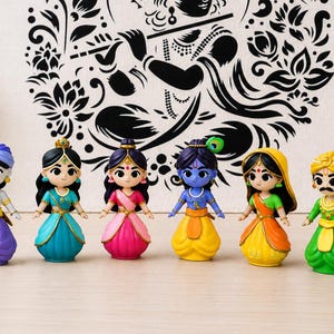 Könnte beinhalten: Sechs farbenfrohe Figuren, die jeweils eine Figur in traditioneller indischer Kleidung darstellen. Die Figuren haben detaillierte Gesichtszüge und sind in leuchtenden Farben wie Blau, Rosa, Gelb und Grün gekleidet. Im Hintergrund befindet sich eine dekorative Kulisse.