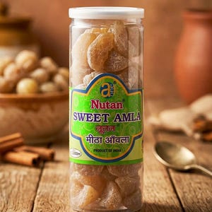 May include: A transparent jar of sweet amla candies, with a green and blue label displaying "SWEET AMLA" and "PRODUCT OF INDIA". The candies are light brown. The jar is on a wooden surface. The jar contains approximately 200g of product.