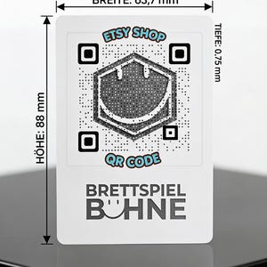 May include: A white rectangular card featuring a central QR code with a smiley face icon, the text ETSY SHOP, QR CODE, and BRETTSPIEL B&Uuml;HNE. Dimensions are marked as 63.7 mm wide, 88 mm high, and 0.75 mm deep, with arrows indicating the measured edges.