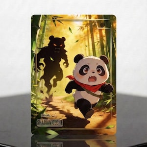 Può includere: Una carta collezionabile rettangolare raffigurante un panda in stile cartoon che corre in una foresta di bambù, inseguito da una creatura scura. La carta riporta la scritta SHADOW CLONE in basso e presenta un bordo dorato con una piccola icona.