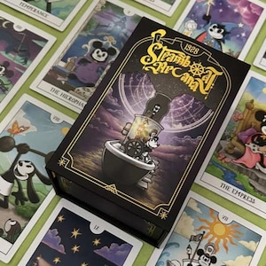 以下が含まれることがあります： Steamboat Arcana 1928と金色の文字が記された黒い長方形のカードボックス。ボートを操縦する漫画のキャラクターのイラストが描かれています。ボックスの周囲には、様々な漫画のキャラクターが描かれたタロットカードが複数並べられています。
