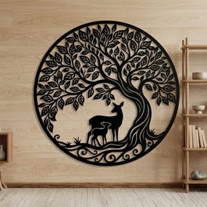 Puede incluir: Arte mural de metal negro que representa un árbol con hojas, un ciervo y un cervatillo, todo dentro de un marco circular. La obra de arte está montada en una pared de paneles de madera clara, con una estantería de madera en el fondo.