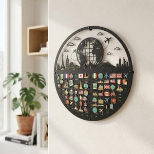 May include: A circular black metal wall display board featuring a globe silhouette, iconic world landmarks, and small airplanes at the top. The lower section contains numerous horizontal slots filled with various colorful travel souvenir pins.