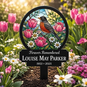 May include: A circular memorial garden stake featuring a stained glass style illustration of a robin perched among pink tulips and white daisies. The black base displays the text Forever Remembered, the name LOUISE MAY PARKER, and the years 1953-2025.