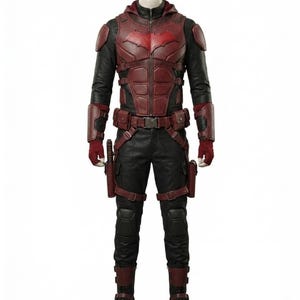 Könnte beinhalten: Ein Ganzkörperkostüm in Rot und Schwarz. Es besteht aus einer Kapuzenjacke mit Fledermaussymbol, Brustplatte, Handschuhen, Hose und Stiefeln. Das Outfit hat ein taktisches Design mit Taschen und einem Gürtel.