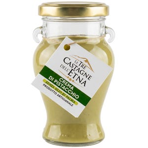 Peut inclure: Un pot en verre transparent avec un couvercle doré, rempli d'une crème de pistache vert clair. Une étiquette blanche avec du texte vert indique "Le Tre Castagne dell'Etna Crema di Pistacchio". Le pot a de petites anses.