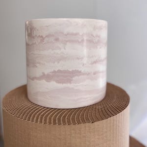May include: A trio of ceramic mugs with a speckled, matte finish in cream, light grey, and dark grey. The mugs have a simple, minimalist design, suitable for coffee or tea.