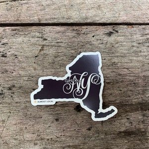 May include: A black and white sticker of the state of New York with the text "QJPOTATS NY" and "ALMOST LOCAL" in a white font.
