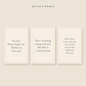 Puede incluir: Un conjunto de tres impresiones rectangulares sobre un fondo beige claro. Cada impresión presenta un borde fino y texto oscuro. Las impresiones muestran afirmaciones y frases que incluyen I'm sorry, Please forgive me, Thank you, I love you y Money flows to me with ease.