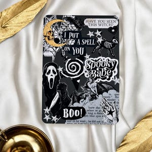 Può includere: Un adesivo rettangolare con un collage in bianco e nero con testo che include "HAVE YOU SEEN THIS WITCH?", "I PUT A SPELL ON YOU", "Spooky Babe" e "BOO!". Il design include una mezzaluna dorata, un gatto scheletro, una figura mascherata e stelle.