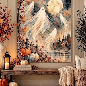 May include: A rectangular wall art print featuring a watercolour-style scene of four white ghosts floating above a landscape with orange autumn leaves, pumpkins, a wooden fence, a small house, a lake, and a large full moon in a dark night sky.