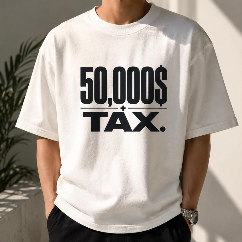 Pu&ograve; includere: Una t-shirt bianca a maniche corte con un testo nero in grassetto sul petto che recita 50,000$ sopra una linea orizzontale, con la parola TAX. stampata in grandi lettere maiuscole nere sotto la linea, incluso un piccolo simbolo pi&ugrave;.
