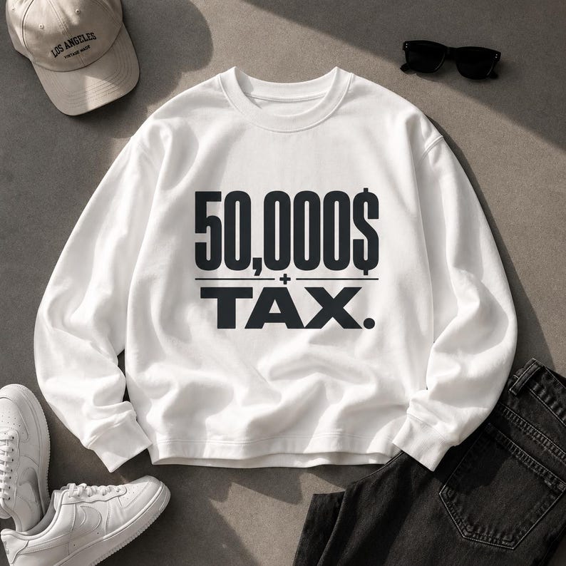 Pu&ograve; includere: Una felpa bianca a maniche lunghe con girocollo e la scritta nera 50,000$ + TAX stampata sul petto. Il capo presenta collo, polsini e orlo a coste ed &egrave; mostrato insieme a un cappellino beige, occhiali da sole neri, scarpe da ginnastica e jeans neri.