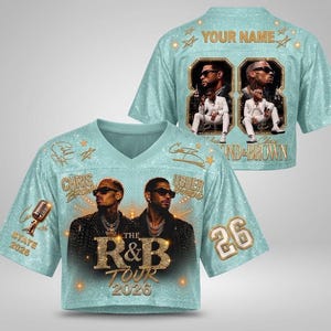 May include: A light blue V-neck crop jersey featuring a glittery texture, gold star accents, and the text "THE R&B TOUR 2026". The front displays portraits of Chris Brown and Usher, a microphone, and the number 26. The back includes "YOUR NAME" and photos.
