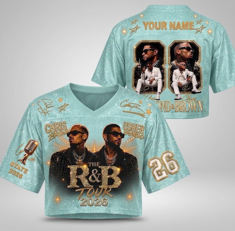 May include: A light blue V-neck crop jersey featuring a glittery texture, gold star accents, and the text "THE R&B TOUR 2026". The front displays portraits of Chris Brown and Usher, a microphone, and the number 26. The back includes "YOUR NAME" and photos.