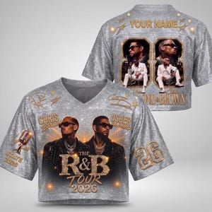 May include: A silver glitter-textured V-neck jersey featuring photographic prints of Chris Brown and Usher, the text "THE R&B TOUR 2026", "STATE 2026", "26", and "YOUR NAME". The design includes gold-toned accents, a microphone graphic, and star motifs.